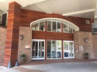 Hardwood cladding framing an arched hotel entrance